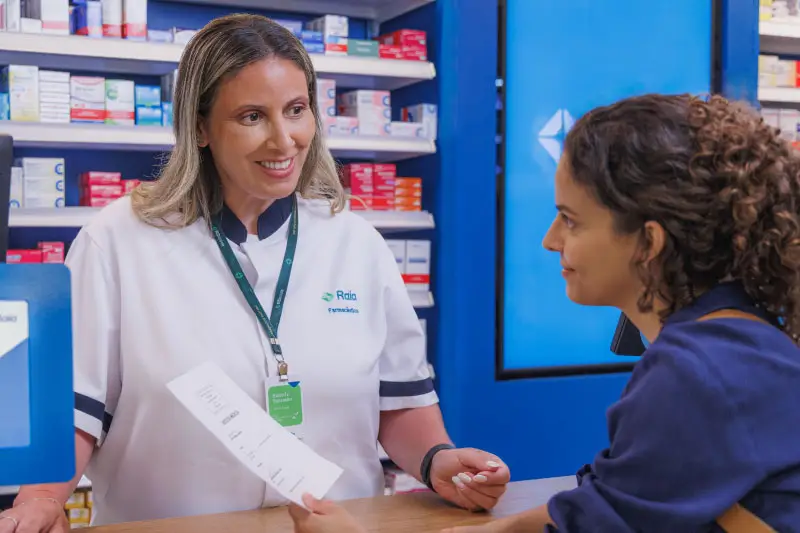 Farmaceutica atendendo uma cliente no balc&atilde;o da farm&aacute;cia